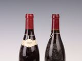 deux bouteilles de vin posées sur une table l'une à côté de l'autre