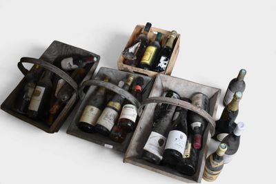 Plusieurs bouteilles de vin se trouvent dans un coffret en bois posé sur une surface blanche
