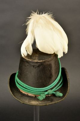 un chapeau noir orné d'une plume sur le dessus