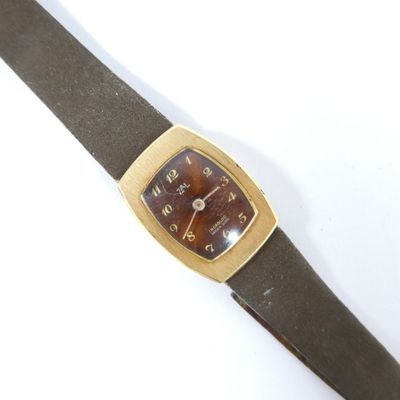une image représentant une montre avec un bracelet en cuir marron sur un fond blanc