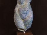 sculpture of a woman sitting on a wooden block