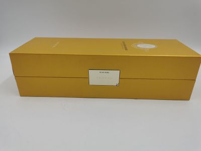 une boîte jaune portant une étiquette, posée sur une surface blanche