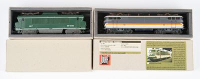deux boîtes contenant un train miniature, posées sur une surface blanche