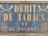 une pancarte sur laquelle on peut lire « dette de tabas et de poudres »
