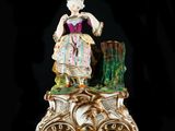 a figurine of a woman sitting on top of a tree stump