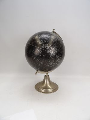un globe noir et doré posé sur une table blanche