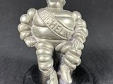 a silver figurine of a man sitting on top of a black base