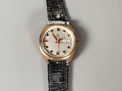 une montre posée sur une surface blanche
