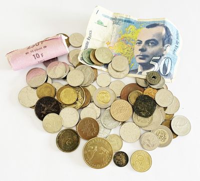 un tas de pièces et un rouleau de billets sur la table