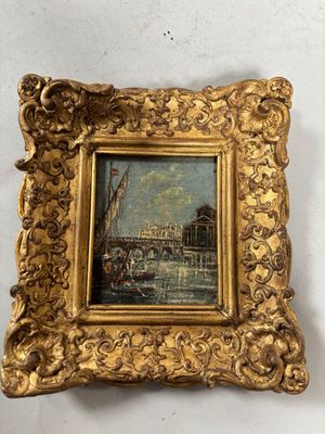 un tableau représentant un cadre doré dans lequel figure un bateau sur l'eau