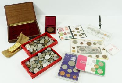 a box of coins and a pen on a table