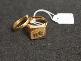 two gold wedding rings with a price tag on top of them