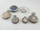 six silver lockes and two silver rings with a blue stone