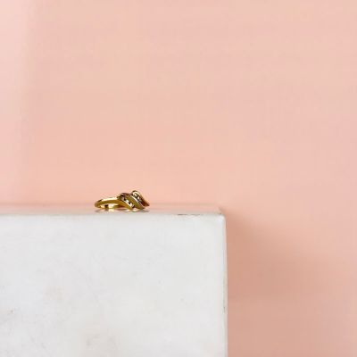 un gros plan d'une alliance en or posée sur un bloc de marbre