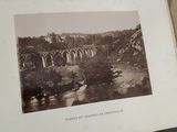 an old photo of a bridge in the middle of a river