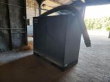 a black refrigerator in a garage with a door open