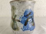 a close up of a blue and white vase on a table