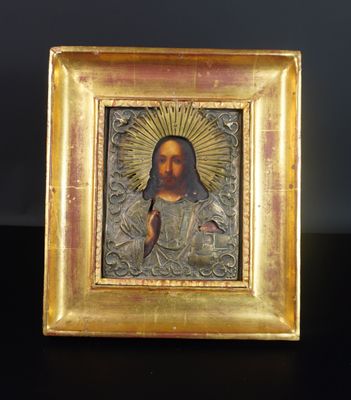 une image représentant un portrait de Jésus dans un cadre doré posé sur une table