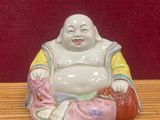 une figurine représentant un Bouddha souriant, posée sur une table