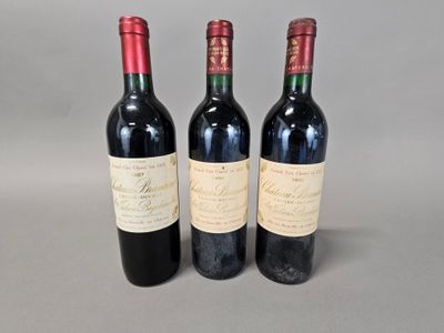 three bottles of red wine sitting next to each other on a table