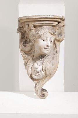 sculpture représentant la tête d'une femme, posée sur un socle blanc