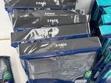 several packs of toothbrushes are sitting on a counter next to a package of toothpaste