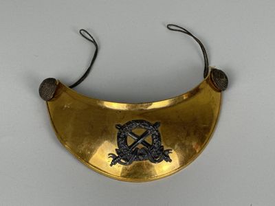 collier plaqué or orné d'un emblème noir et blanc