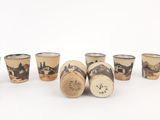 several shot glasses are lined up in a row on a white surface