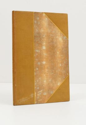 un vieux livre posé sur une table blanche à côté d'un mur blanc