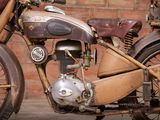 a old motorcycle parked in front of a brick wall