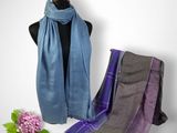 a close up of a scarf on a mannequin with flowers in the background