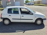 a small white car that is parked in a parking lot
