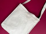 white canvas bag with a cross on it on a red surface