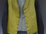 a yellow and black jacket hanging on a wall next to a blue wall