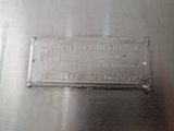 un gros plan d'une plaque métallique sur laquelle figure une plaque signalétique