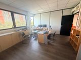 une pièce équipée d'un bureau, de chaises et d'un ordinateur posé dessus