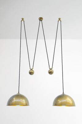 a pair of brass pendant lights hanging from the ceiling