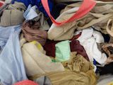 a pile of clothes that is sitting on a bed