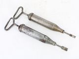 deux outils métalliques posés sur une surface blanche