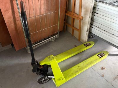 un diable jaune posé dans un garage, près d'une porte