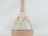 a white vase with pink and gold designs on it