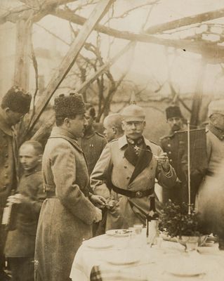 a group of men standing around a table with a cake on it