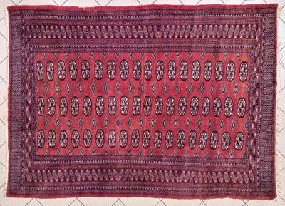 a close up of a red rug on a white surface