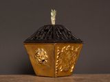 a gold and black box with a bird on top of it