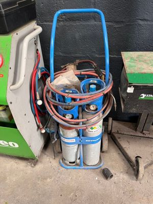 une image représentant un chariot bleu avec plusieurs bidons d'essence