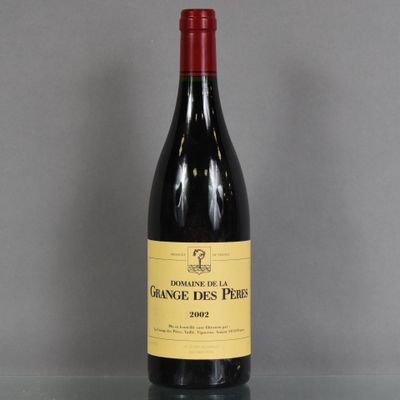 La bouteille de vin rouge est posée sur une table en verre.