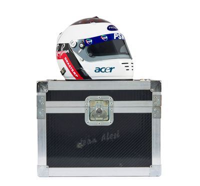 un casque posé sur une valise, sur fond blanc