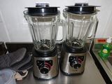two blenders that are sitting on top of a counter