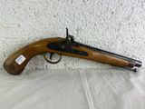 an old gun with a wooden handle on a white surface