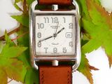 a small square watch sitting on top of a leafy branch